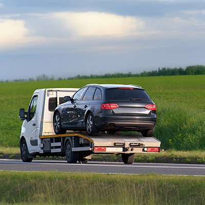 Une voiture noire remorquée sur une camionnette blanche