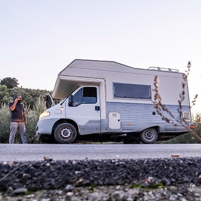 Un homme en plein appel devant son camping-car en panne