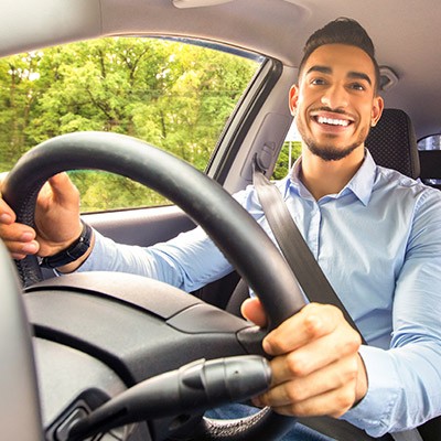 Un homme joyeux au volant de sa voiture