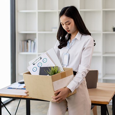 Une jeune femme emportant ses affaires suite à une perte d'emploi