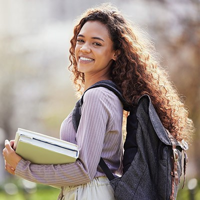 Université, livres et portrait de femme dans le parc sur le campus pour l'apprentissage, l'éducation et la connaissance en plein air. Sac à dos, étudiant universitaire et femme confiante à l'école, l'académie et les études dans la nature