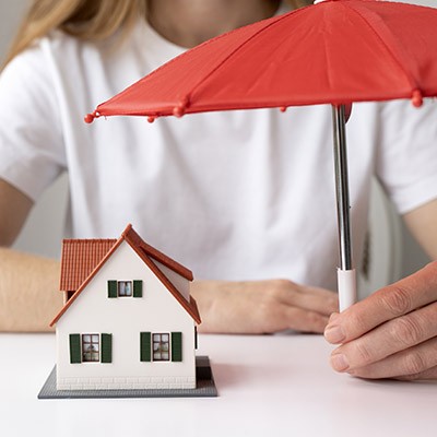Une maison protégé par un parapluie rouge