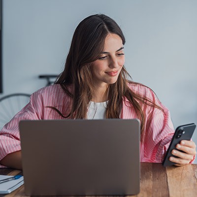 Une jeune femme regardant les offres d'assurances sur son téléphone