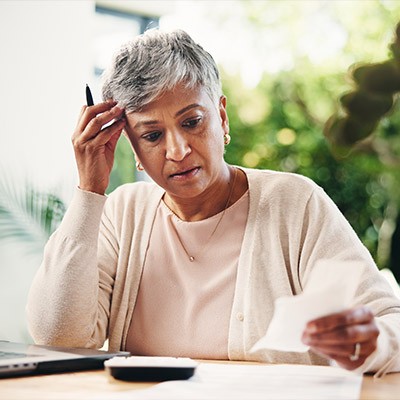 Une jeune retraitée semblant consterné devant une facture