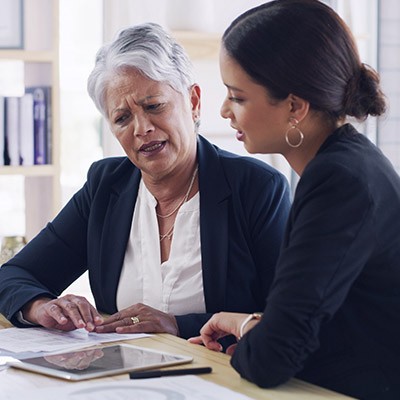 Une femme âgée présentant ses problèmes à son assurance