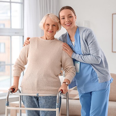 Une jeune soignante aidant sa patiente à se déplacer