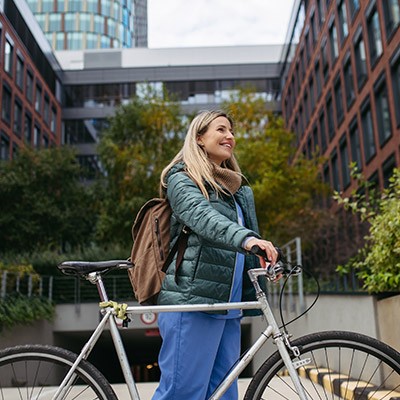 Une jeune femme en route pour le travail avec son vélo