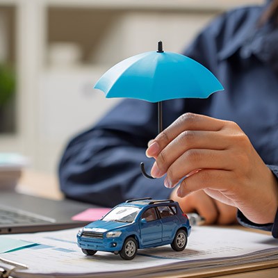 Un parapluie bleu protégeant une voiture miniature